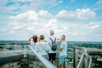 groepje mensen bekijkt de skyline van Mechelen op de skywalk Sint-Romboutstoren